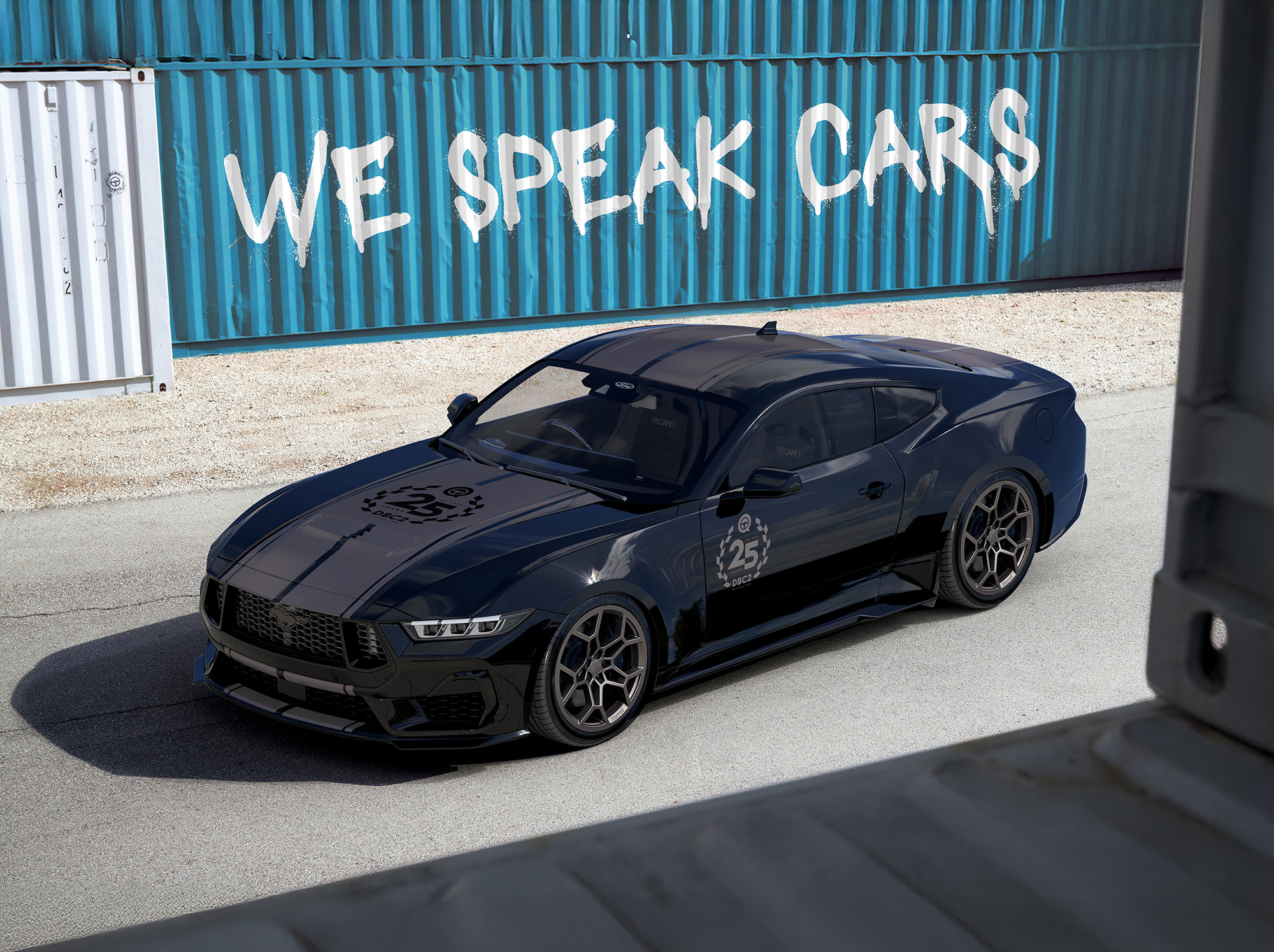 Dark muscle car in front of a shipping container painted with WE SPEAK CARS
